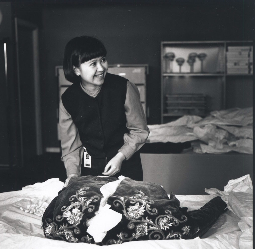 Photograph of Conservator Suzanne Chee working on Dior velvet jacket